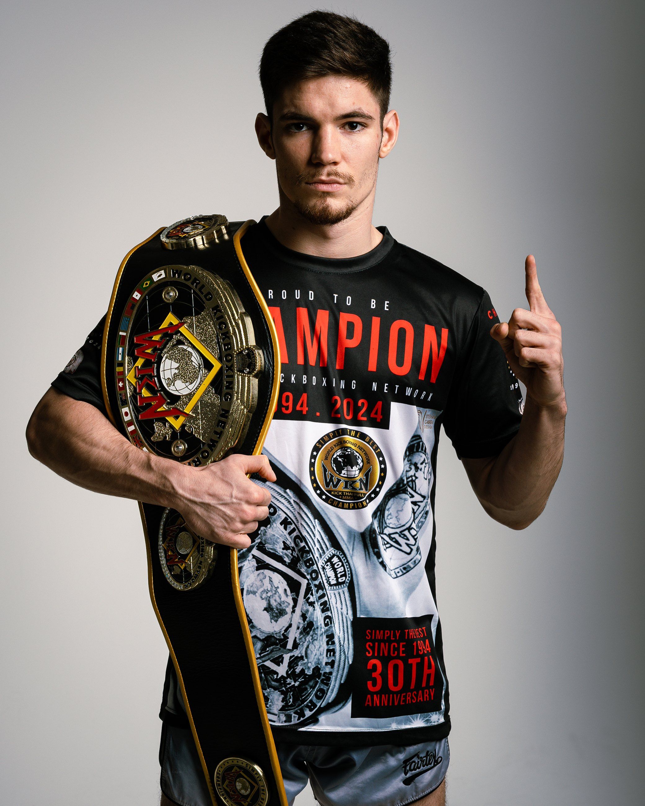 Muay Thai champion holding his title belt