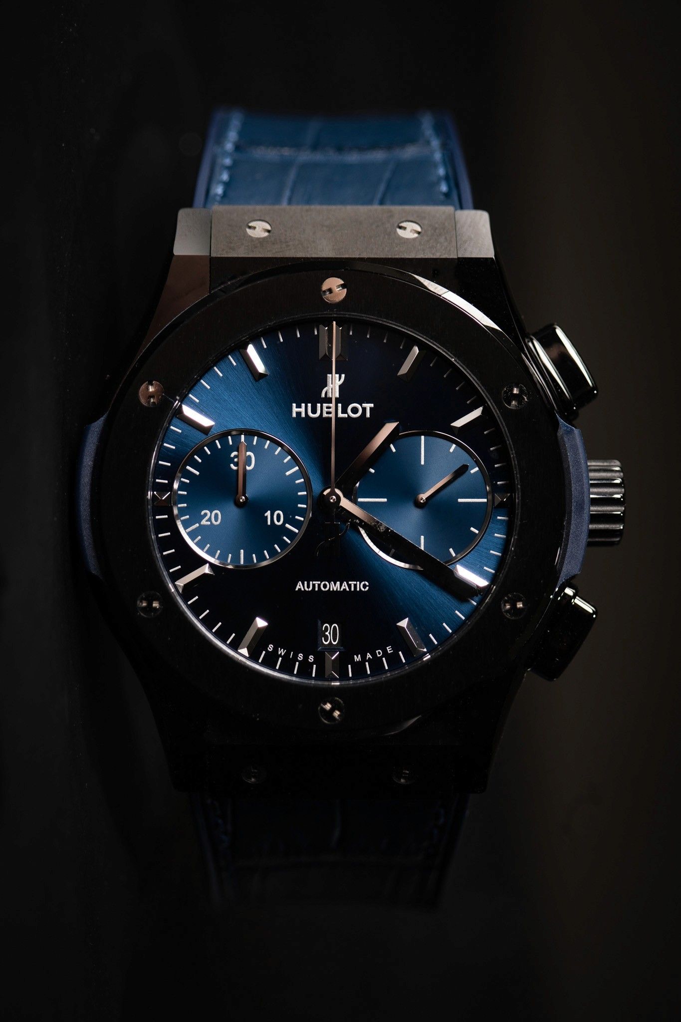 Hublot chronograph on a blue strap, shot in low light