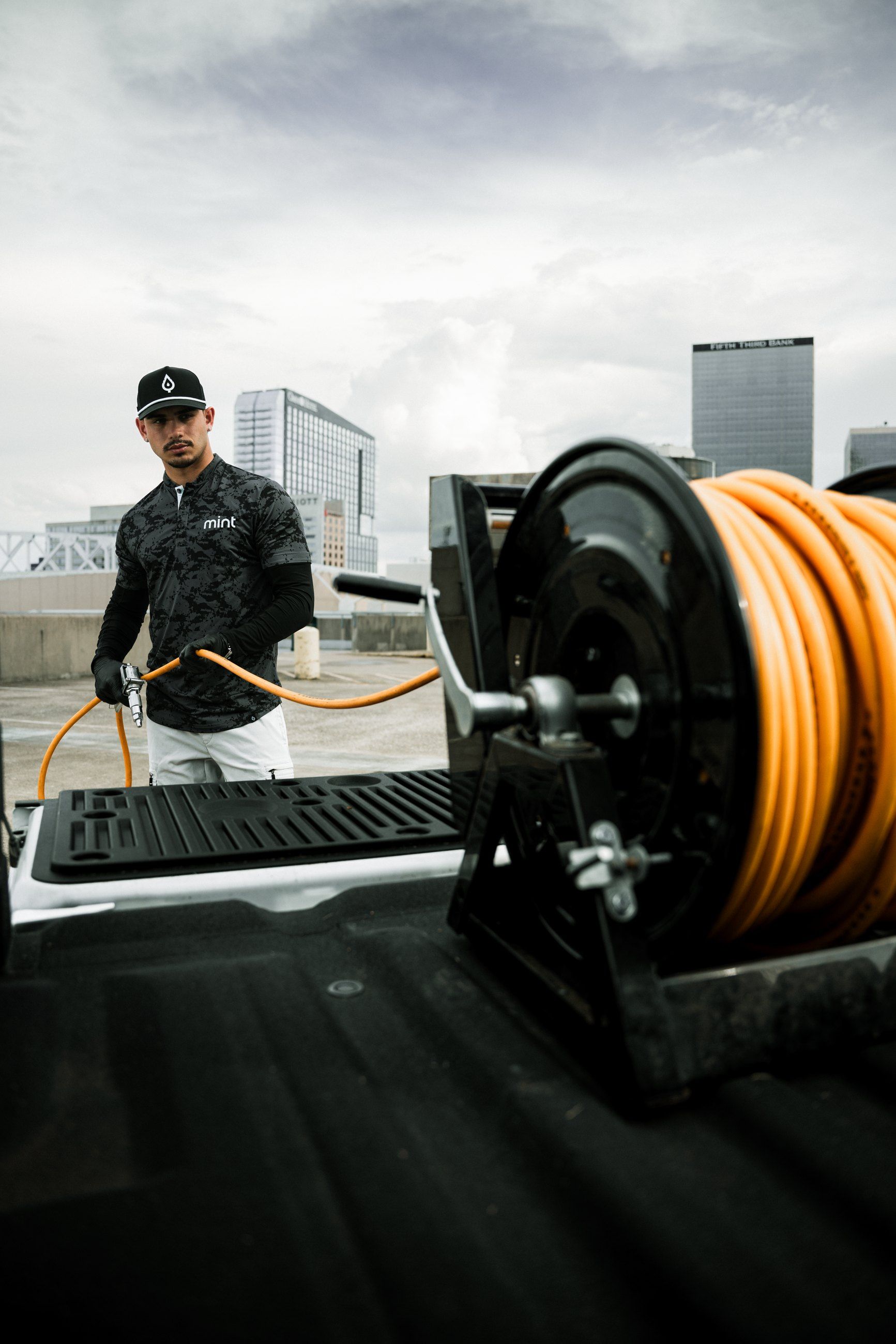 Technician pulling hose from a reel in the truck bed