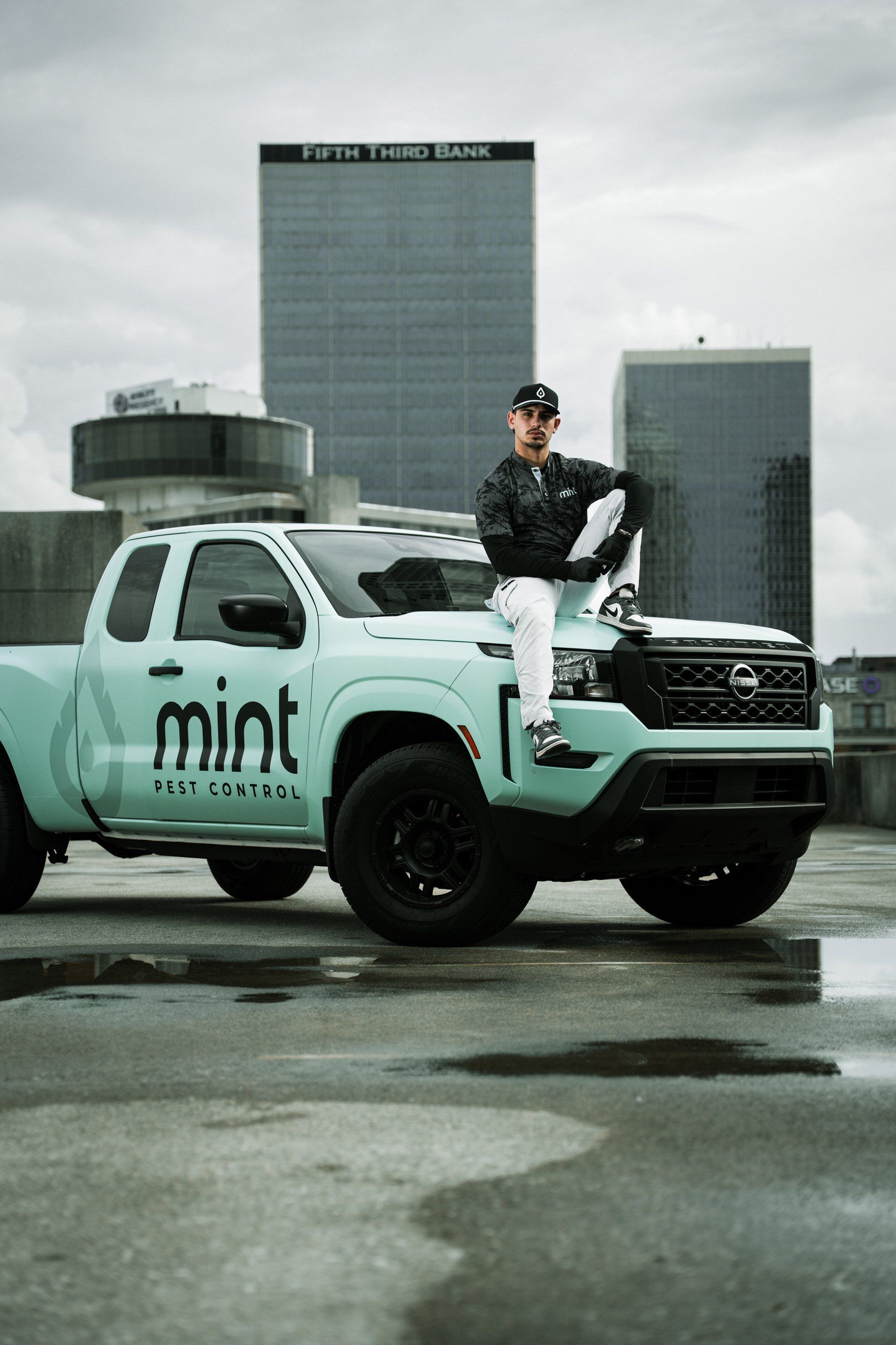 Technician sitting on a branded pickup against the city skyline