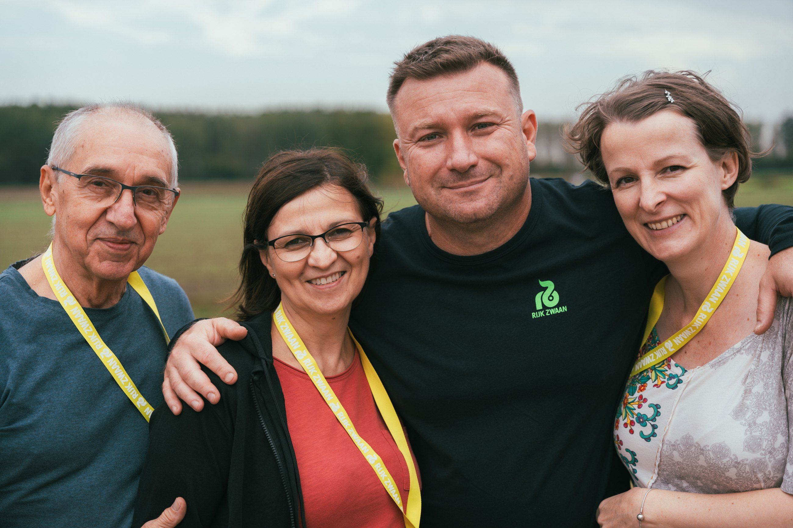 Four colleagues with event lanyards smiling together