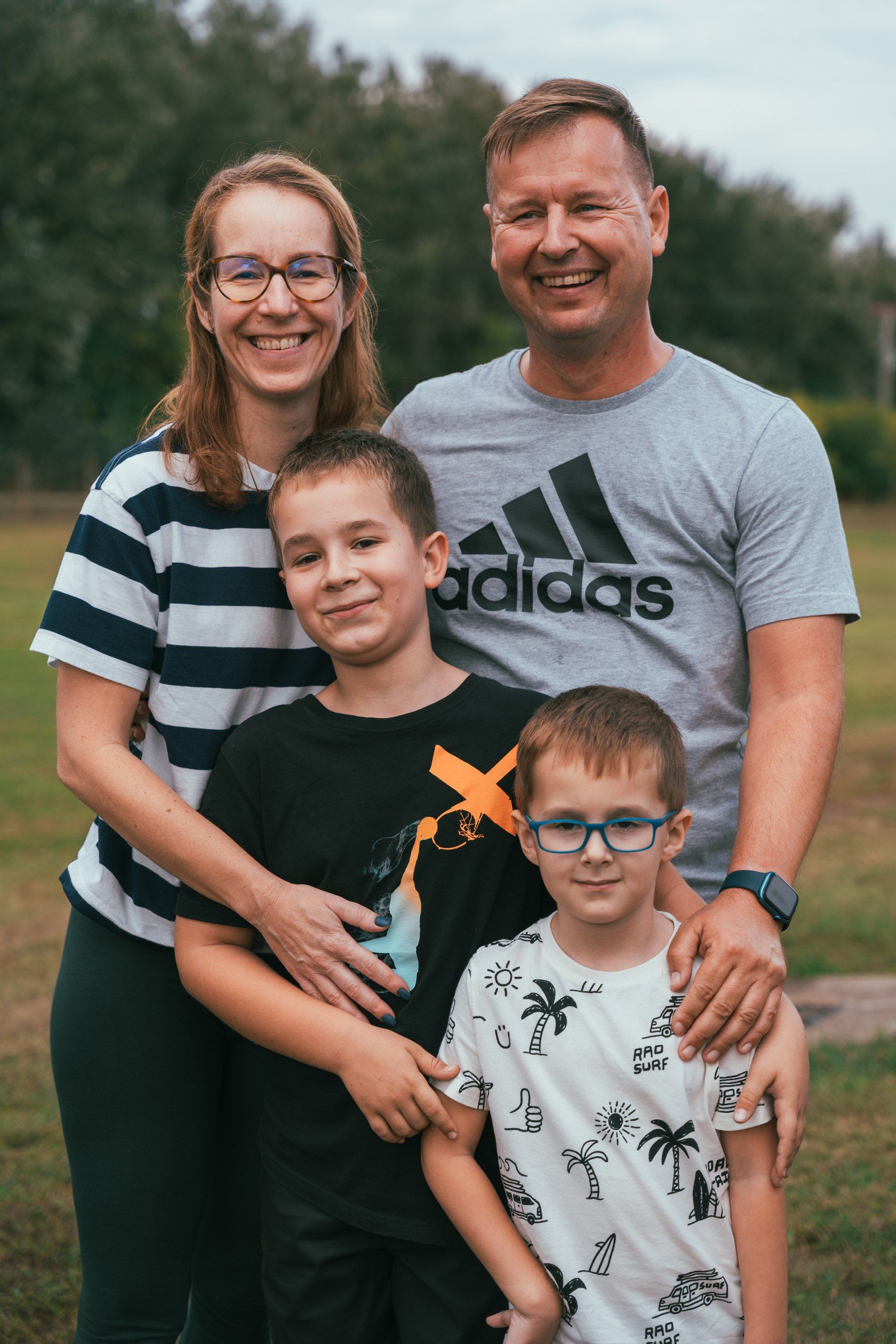 Family of four posing on the lawn