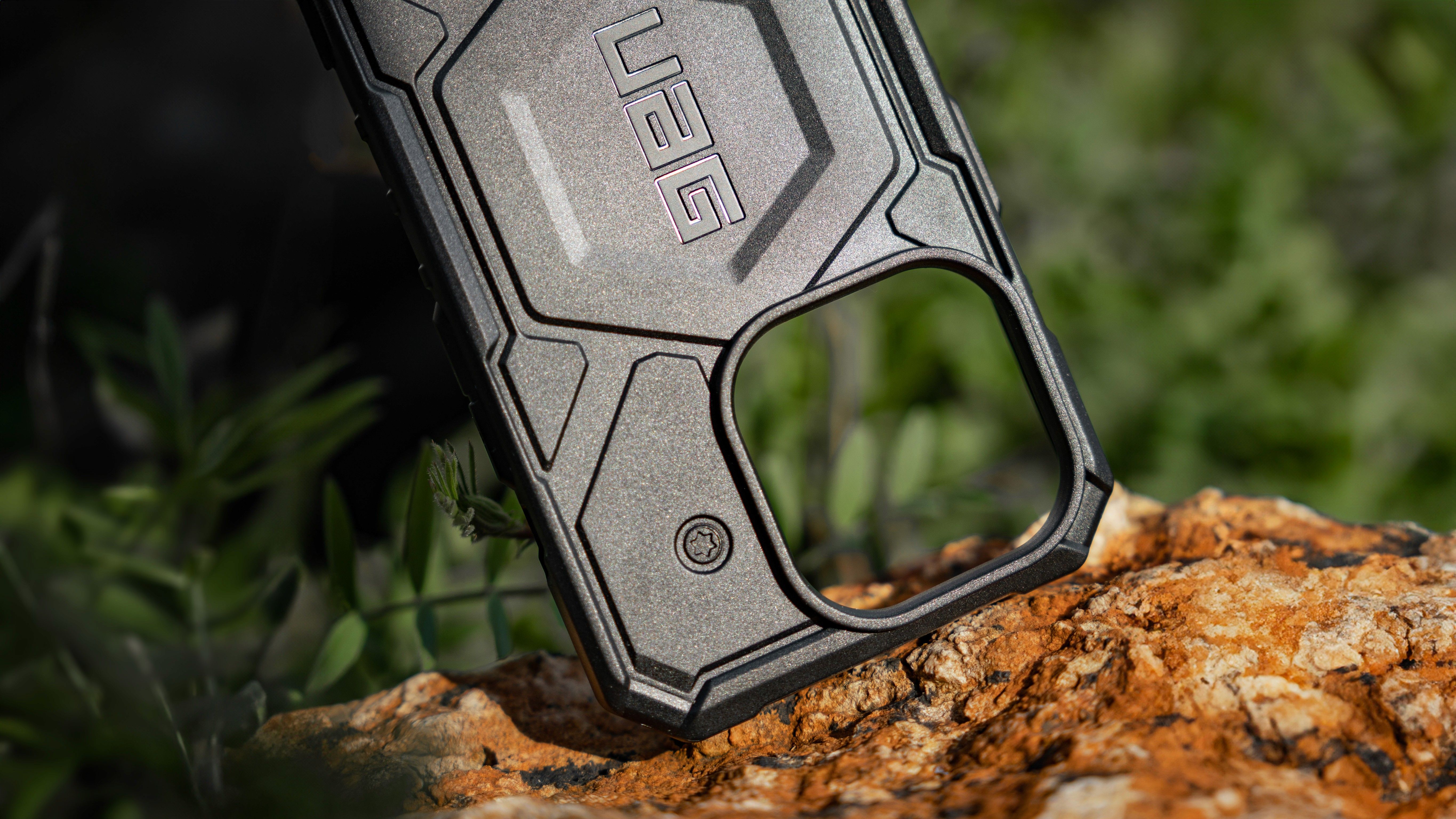 Rugged UAG phone case resting on a mossy rock