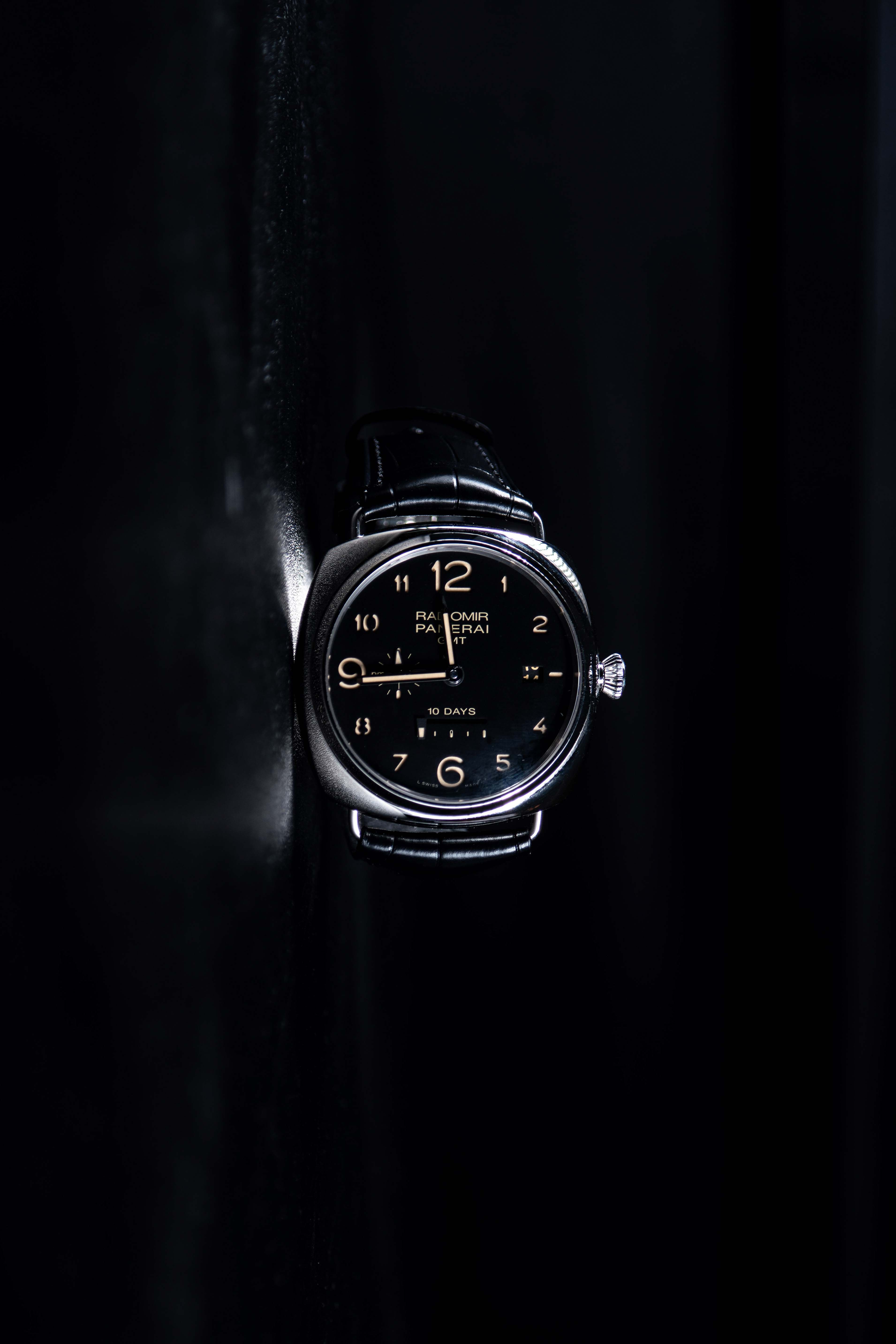 Wristwatch emerging from a black background
